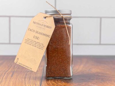 A jar filled with DIY taco seasoning mix, and labeled with a tag.