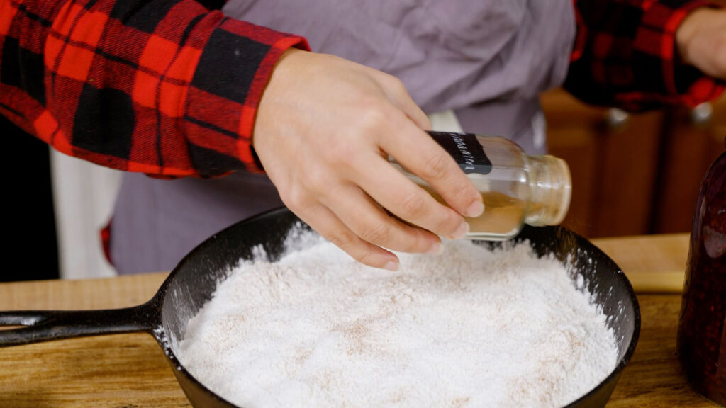 Adding spices to an apple pie dump cake.