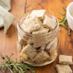 A glass jar full of sour cream and onion crackers.