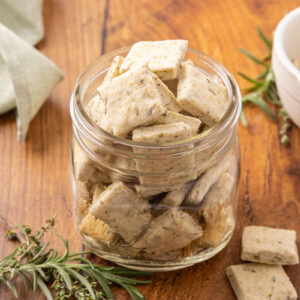 A glass jar full of sour cream and onion crackers.