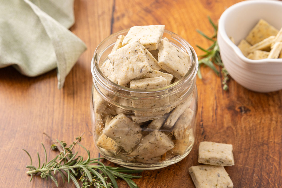 A glass jar full of sour cream and onion crackers.