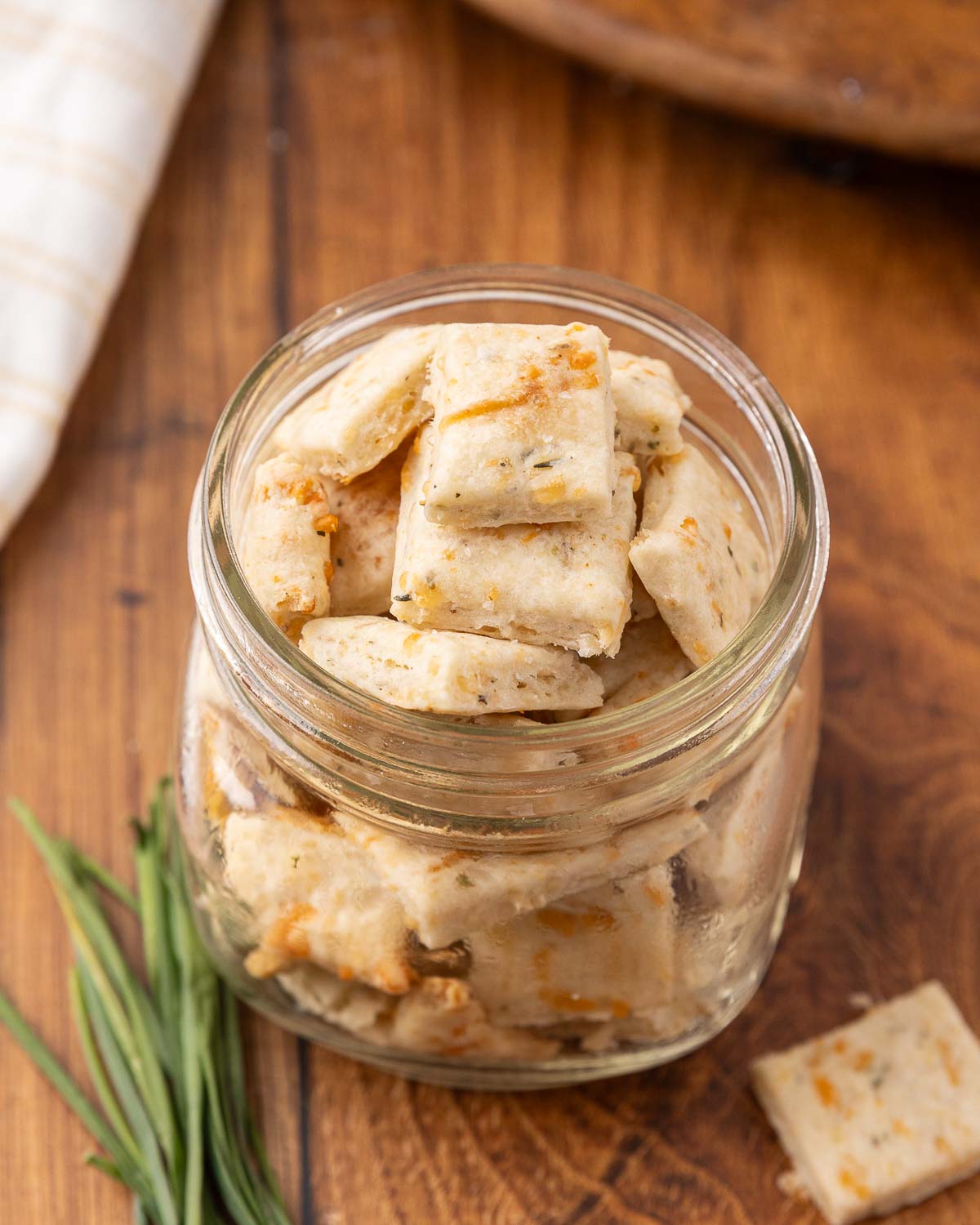 A glass jar full of sour cream and onion crackers.