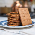 A stack of homemade graham crackers on a plate.