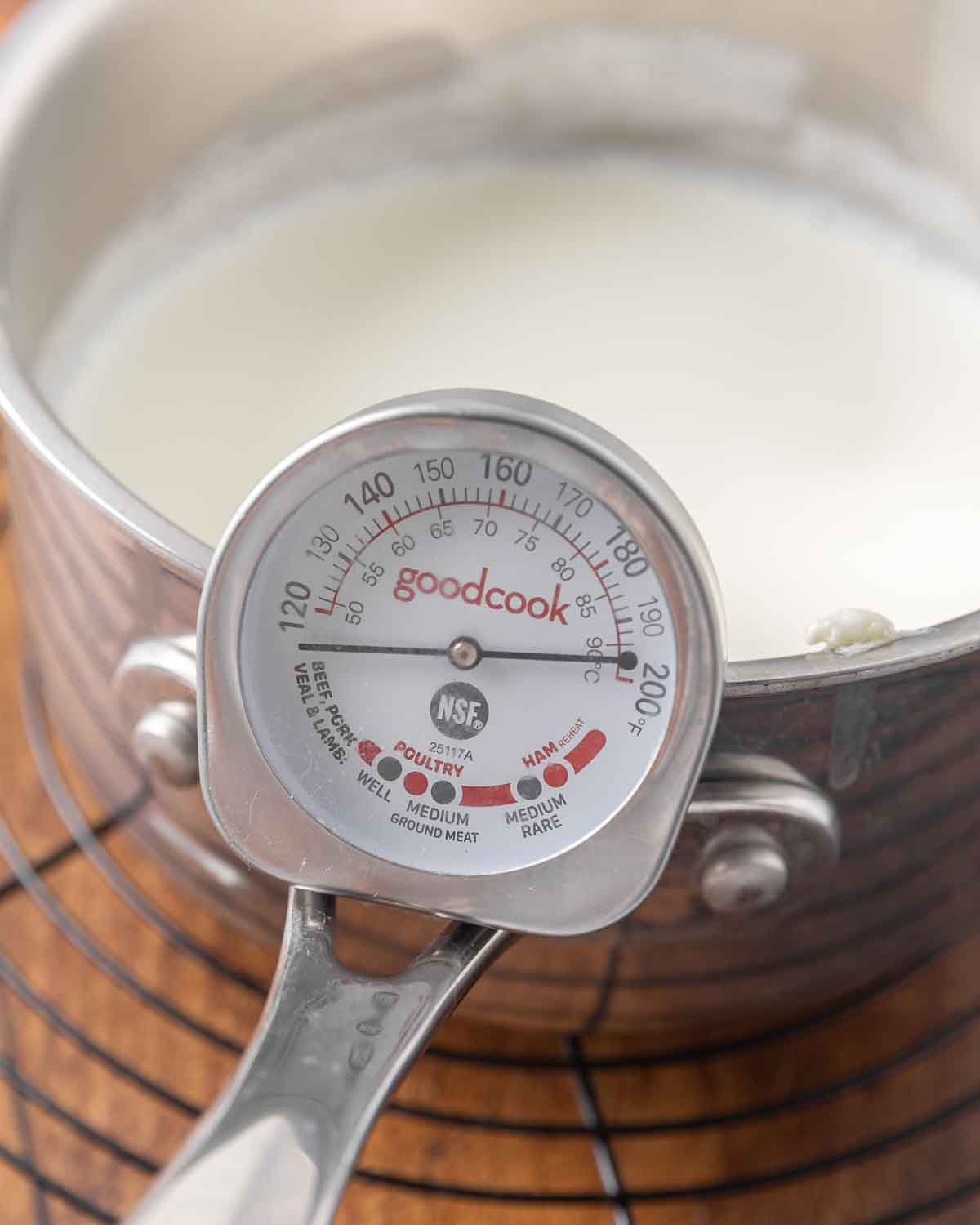 A saucepan full of cooled milk with a thermometer showing 110&deg;F.