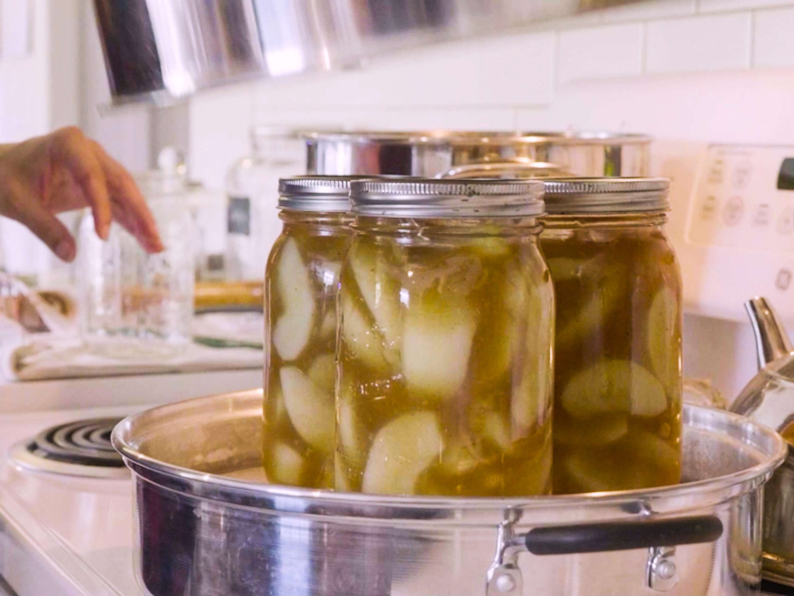 Mason jars filled with apple pie filling sitting in a steam canner.