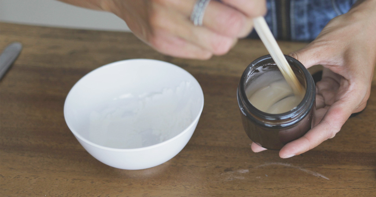 A woman making a paste with baking soda and water.