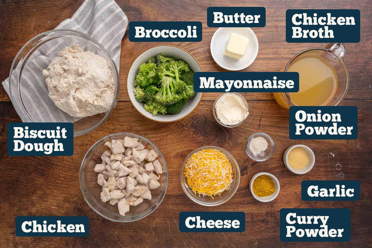 Chicken and broccoli casserole with curry ingredients: chicken, broccoli, biscuit dough, butter, mayo, chicken broth, onion powder, garlic, curry powder, and cheese.