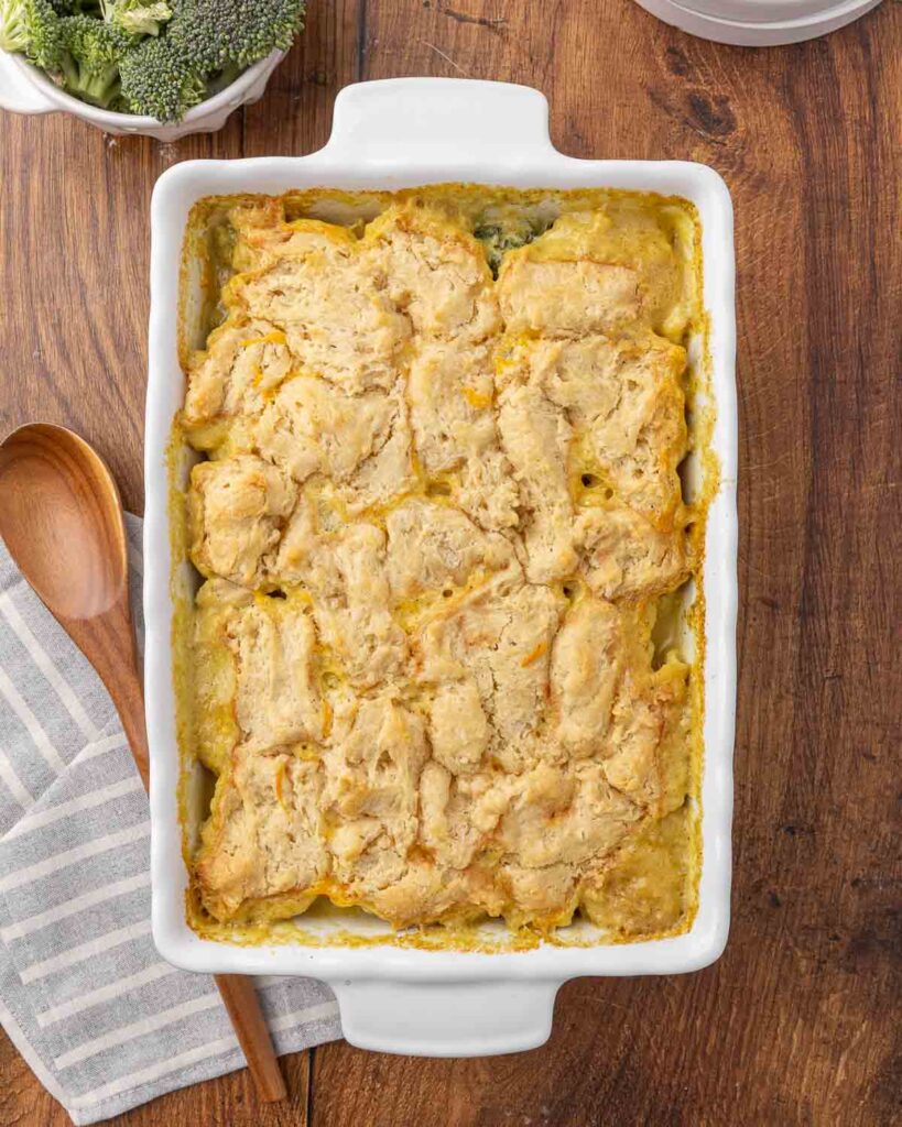 A bird's eye view of a freshly baked chicken and broccoli casserole in a white baking dish.