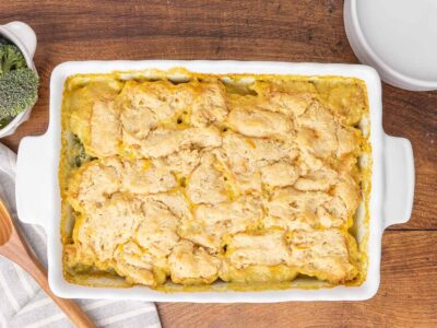 A bird's eye view of a freshly baked chicken and broccoli casserole in a white baking dish.