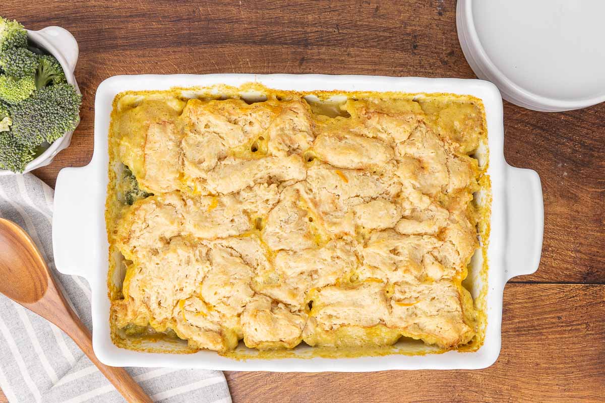 A bird's eye view of a freshly baked chicken and broccoli casserole in a white baking dish.