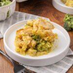 A serving of chicken and broccoli casserole with curry on a white plate.