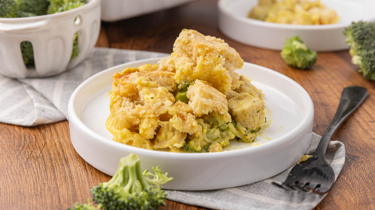 A serving of chicken and broccoli casserole with curry on a white plate.
