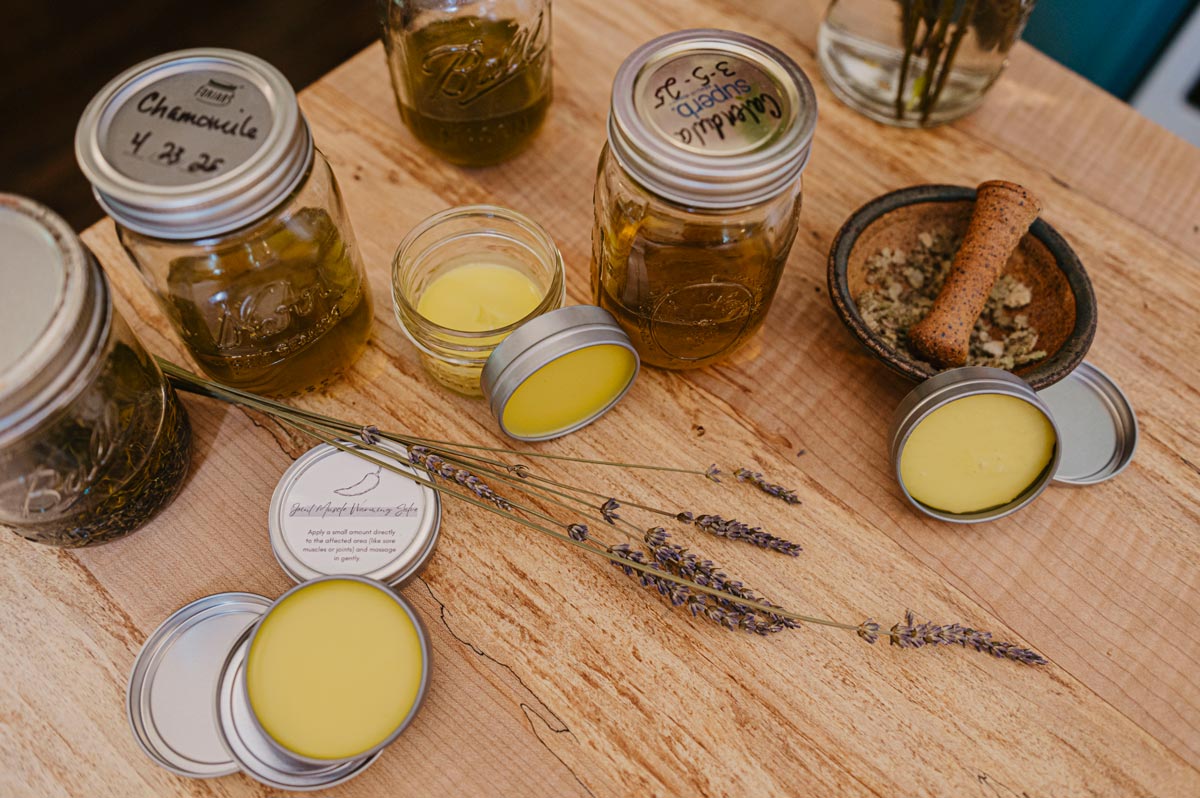 Homemade herbal salves and oils on the counter.