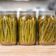 Jars of canned pickled asparagus on a counter.