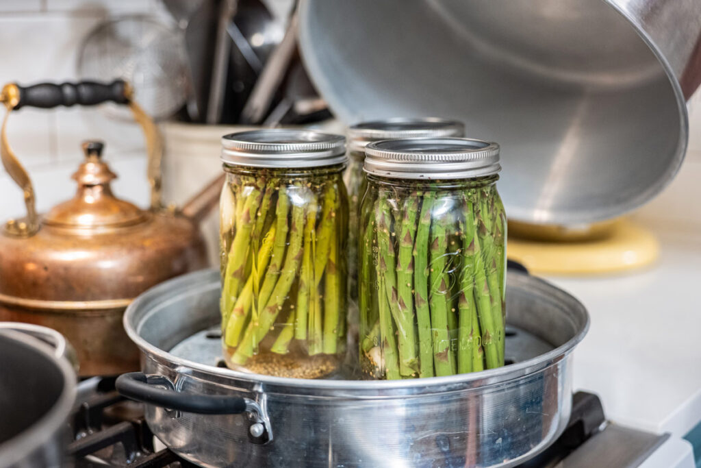 Jars of pickled asparagus in a steam canner.