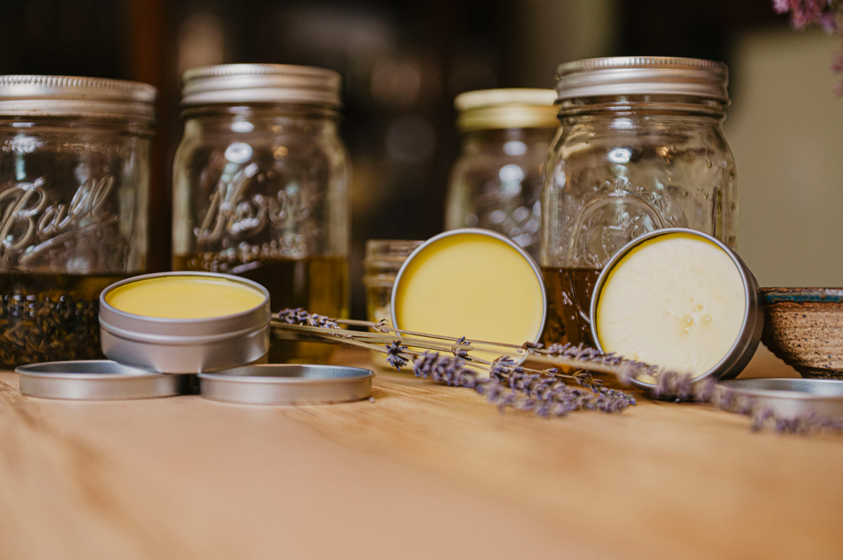 Homemade herbal salves and oils on the counter.