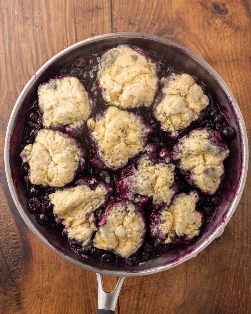 Birdseye view of a skillet filled with blueberry dumplings.
