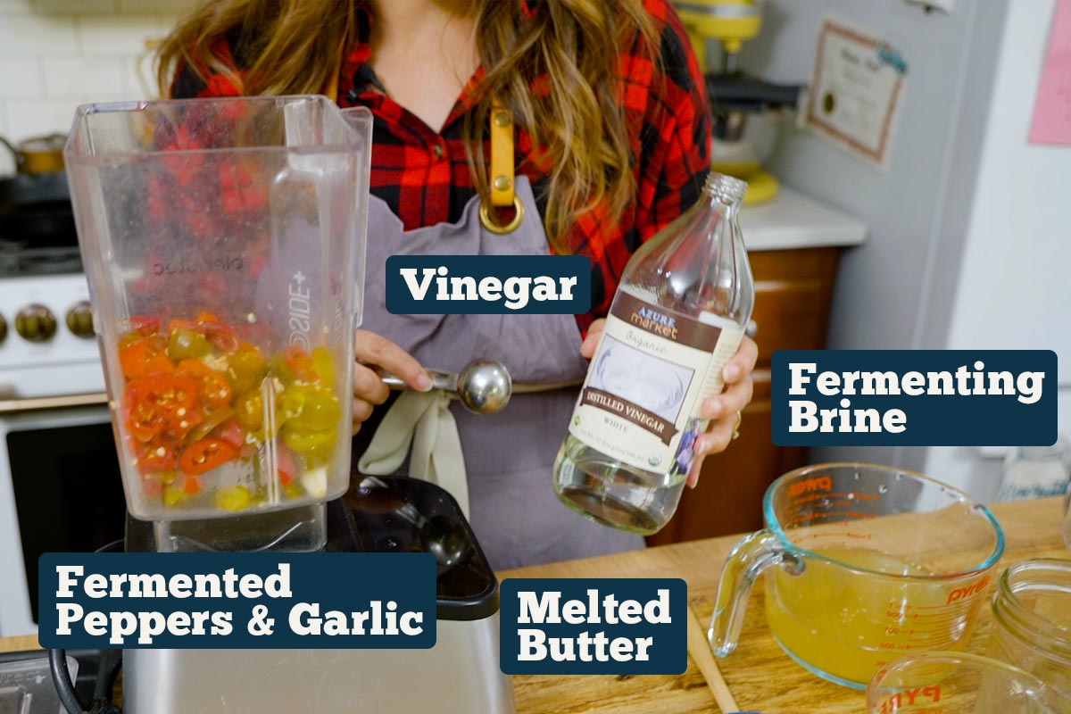 Fermented hot sauce recipe ingredients: fermented peppers, fermenting brine, melted butter, and vinegar.