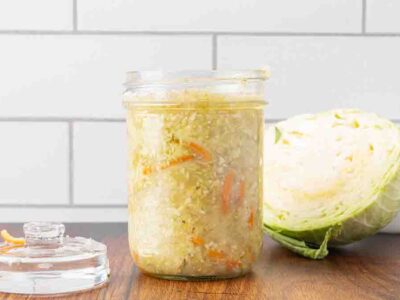 A jar of fermented sauerkraut sitting on a counter.