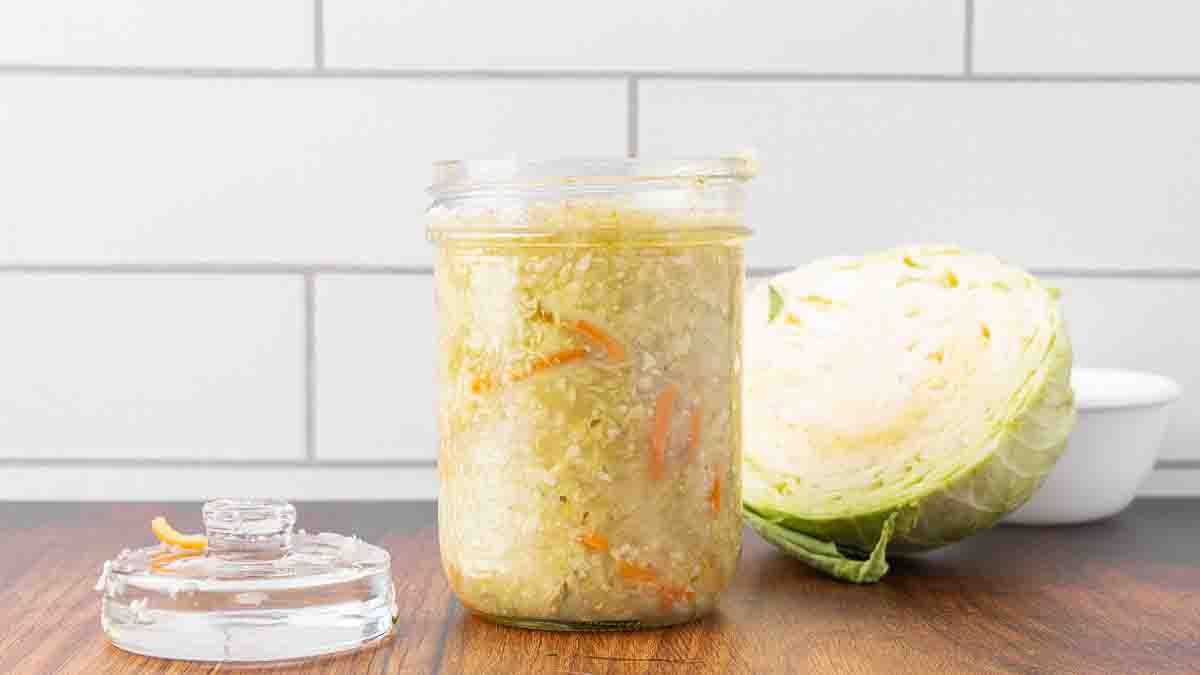 A jar of fermented sauerkraut sitting on a counter.