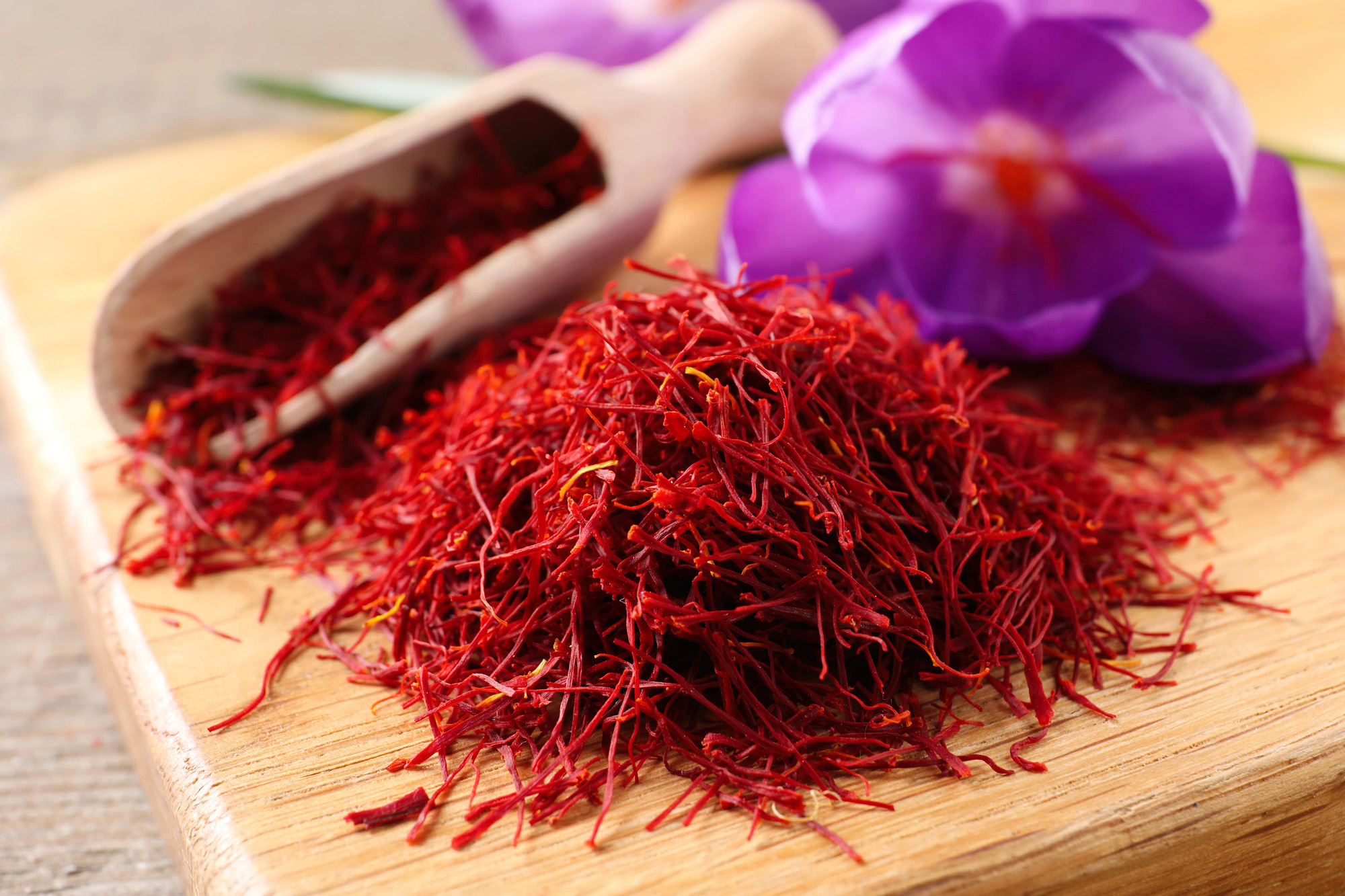 Dried saffron and crocus flowers on wooden board, closeup