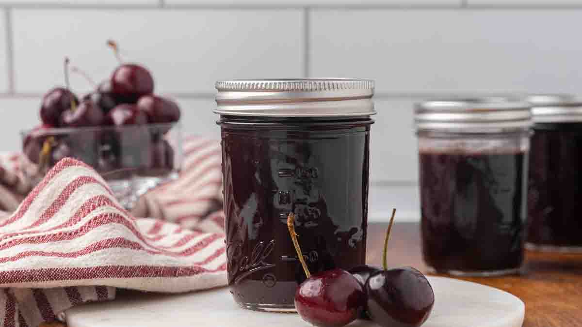 Jars of chocolate cherry sauce sitting on a counter.