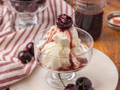 Chocolate cherry sauce served over a dish of vanilla ice cream.