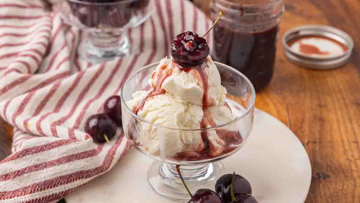 Chocolate cherry sauce served over a dish of vanilla ice cream.